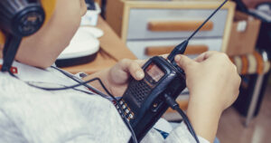 boy adjusting volume while using walkie talkie